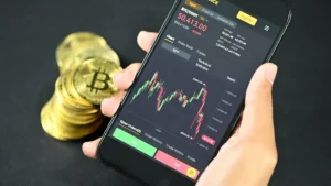 a person holding a phone with a bitcoin on the screen