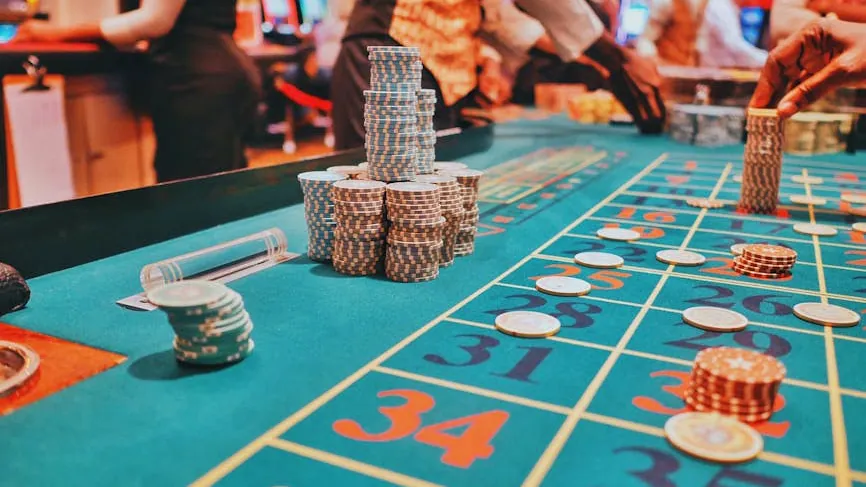 A vibrant view of a casino roulette table with poker chips and players engaged in gambling.