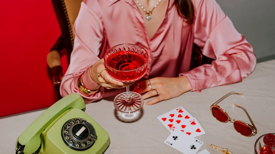 A woman sitting at a table holding a glass of wine