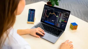 a woman sitting at a table using a laptop computer