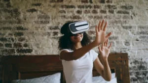 Young woman wearing vr headset, reaching out hands.