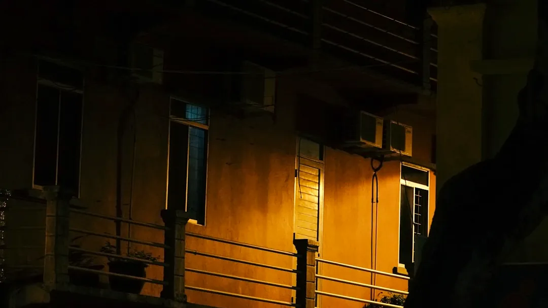 Building exterior illuminated by warm light at night.