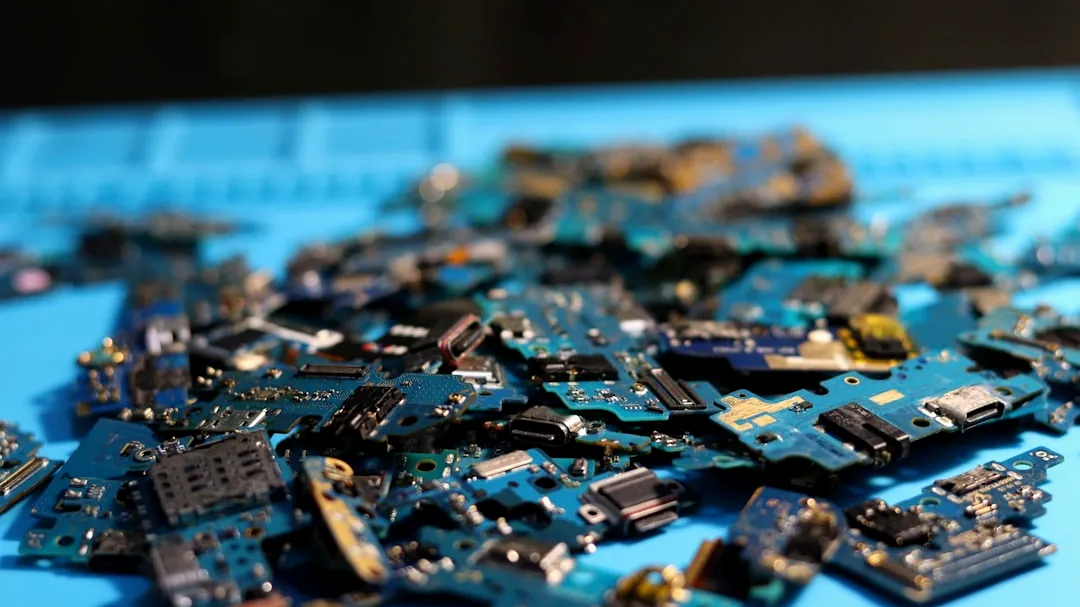 Electronic circuit boards are piled on a blue mat.